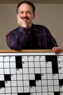 Will Shortz, founder of the American Crossword Puzzle Tournament and the New York Times's puzzle editor, poses Saturday, Feb. 23, 2008 in his Pleasantville, New York home with the contest board that is used during the competition that starts Feb. 29. Shortz hopes there will be more contestants and onlookers as it moves to Brooklyn, New York from 30 years at the former site in Stamford, Connecticut. Photographer: Craig Ruttle/Bloomberg News